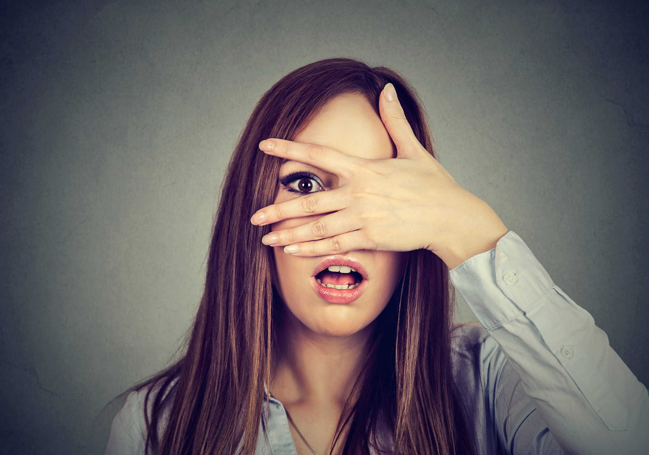 afraid-woman-peeking-through-her-fingers